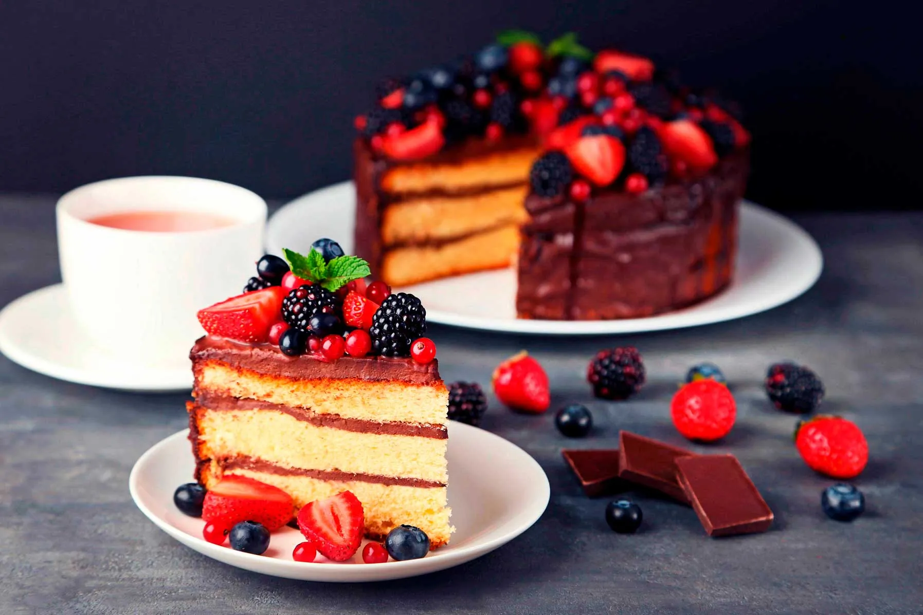 A display case showcasing an assortment of colorful desserts, including cakes, pastries, and tarts.
