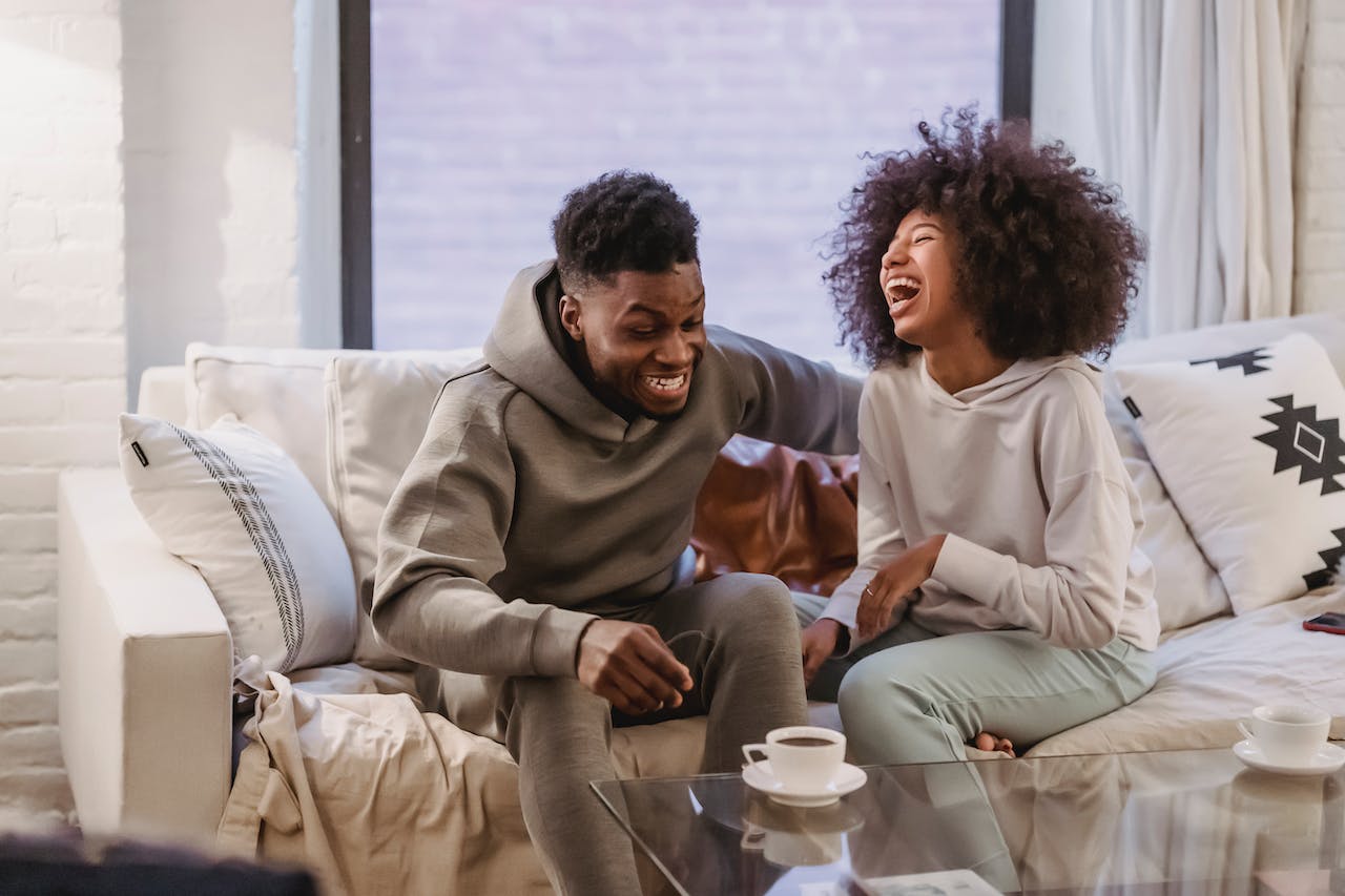 Couple sitting on couch laughing