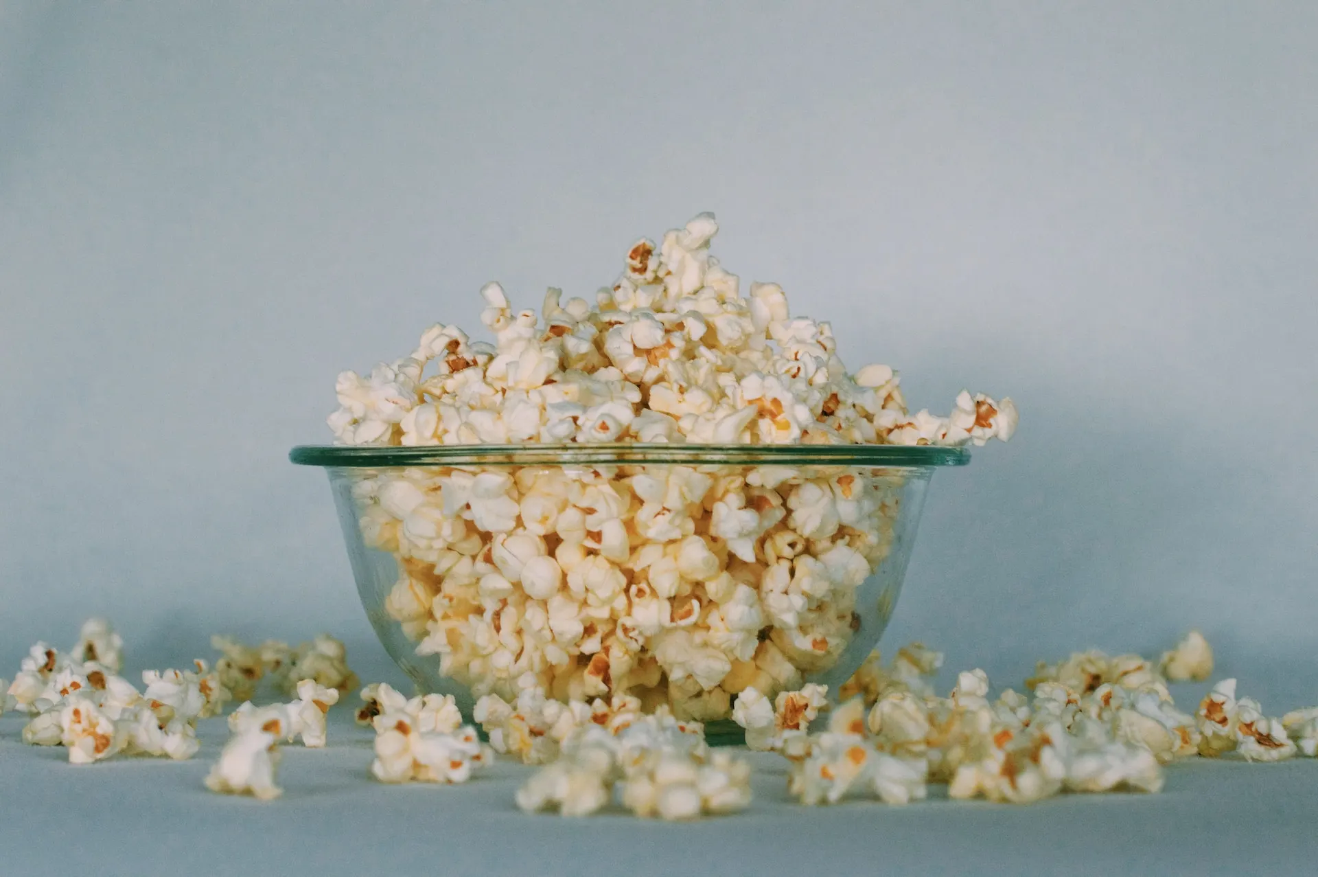 large bowl of popcorn spilling over on a countertop