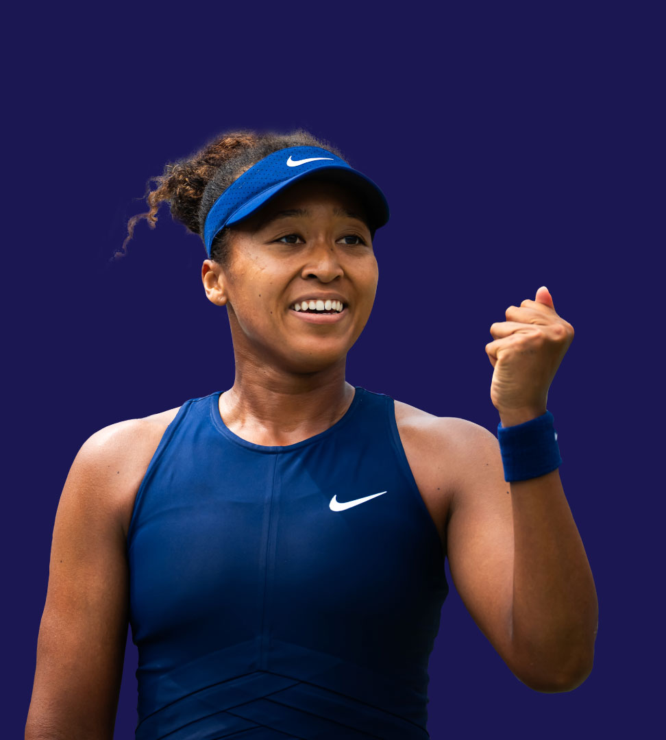 A photo of female tennis player Naomi Osaka in a navy blue tennis outfit and visor celebrating with a clenched fist.