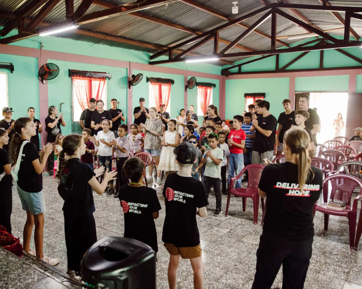 Christ Fellowship students leading a worship gathering with local kids