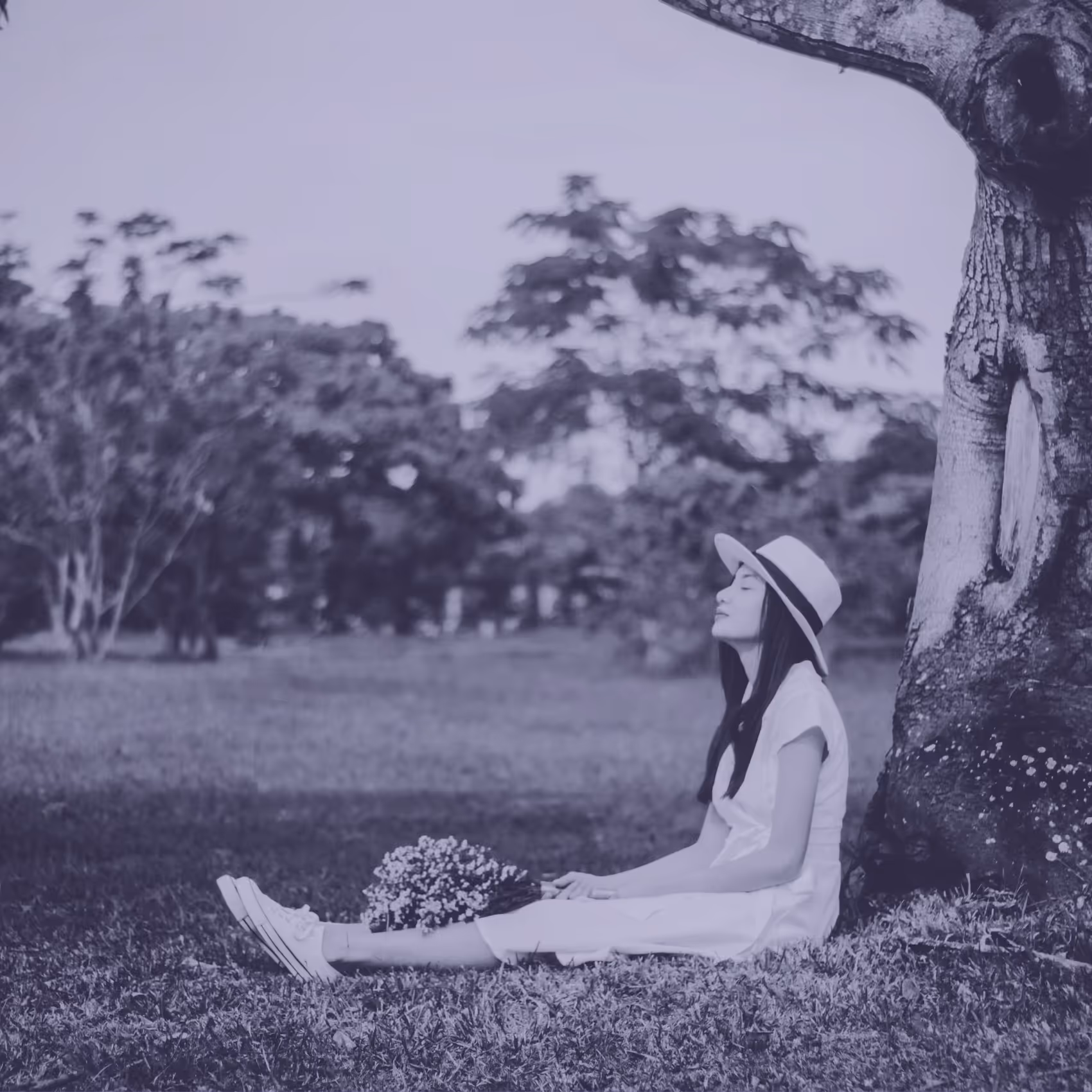 a photo of a person sitting under a tree