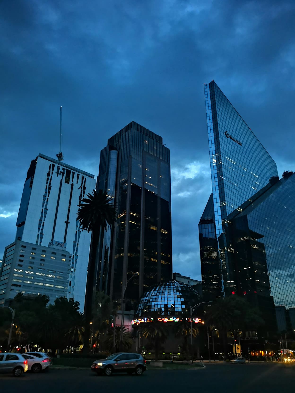Skyscrapers make up the Juárez skyline in Mexico City. Taken at night, the sky is mainly dark blue with clouds. 