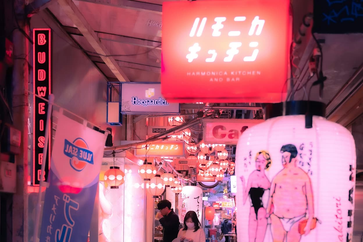 One of the many bright walkways in Kichijoji, Tokyo, featuring neon light signs with drawings and Japanese writing.