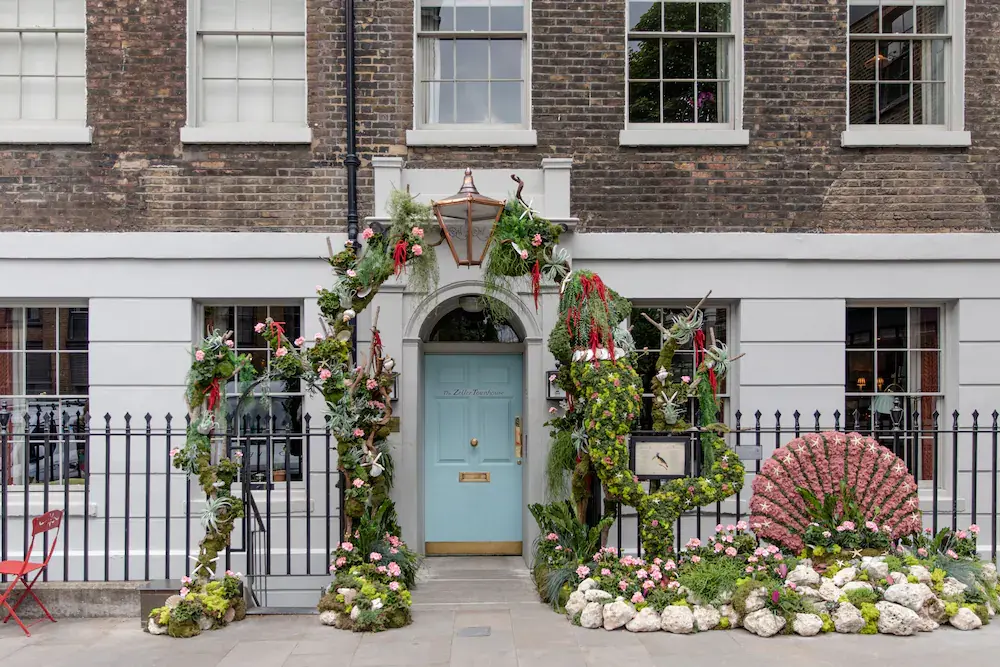 The front of The Zetter Hotel in Clerkenwell, London, covered with a trellis of flowers and plants.