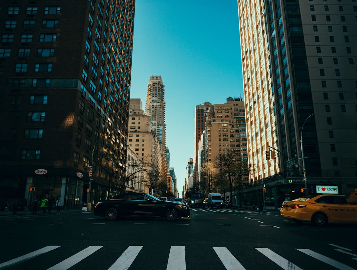 Crosswalk, skyscrapers, and taxis located at east 72nd Street & Lexington Avenue in New York CIty's Upper East Side