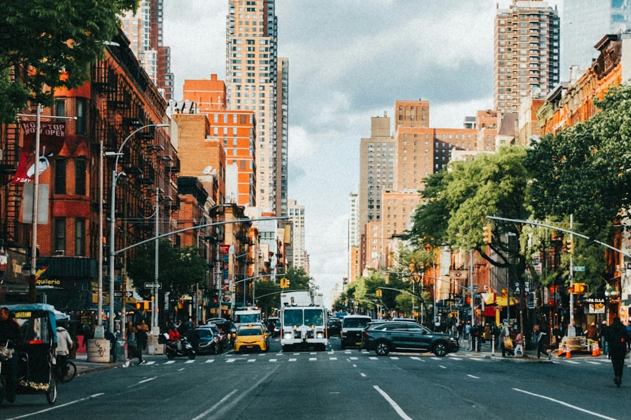 Mid day street and city view of an intersection located in the Hell's Kitchen neighborhood of New York City.