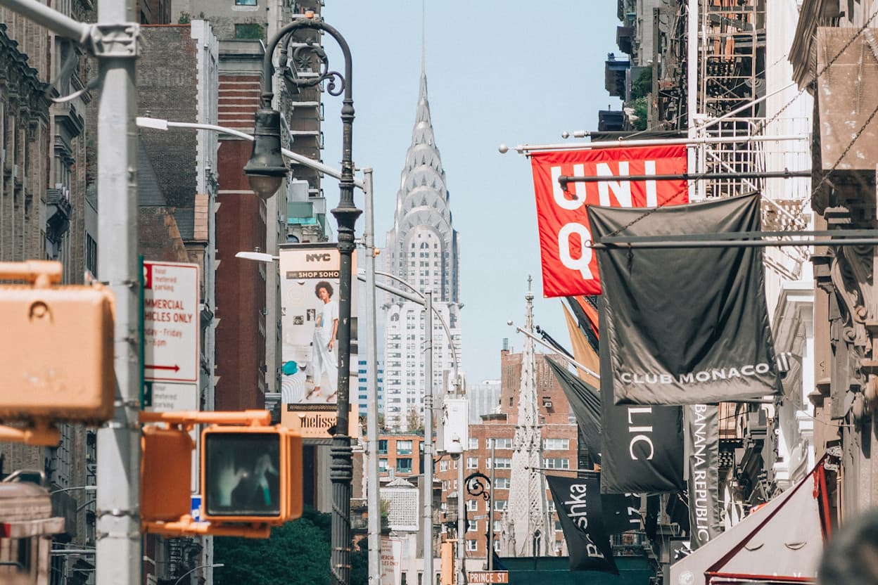 Busy Soho street with shopping, stores, and skyscraper views.