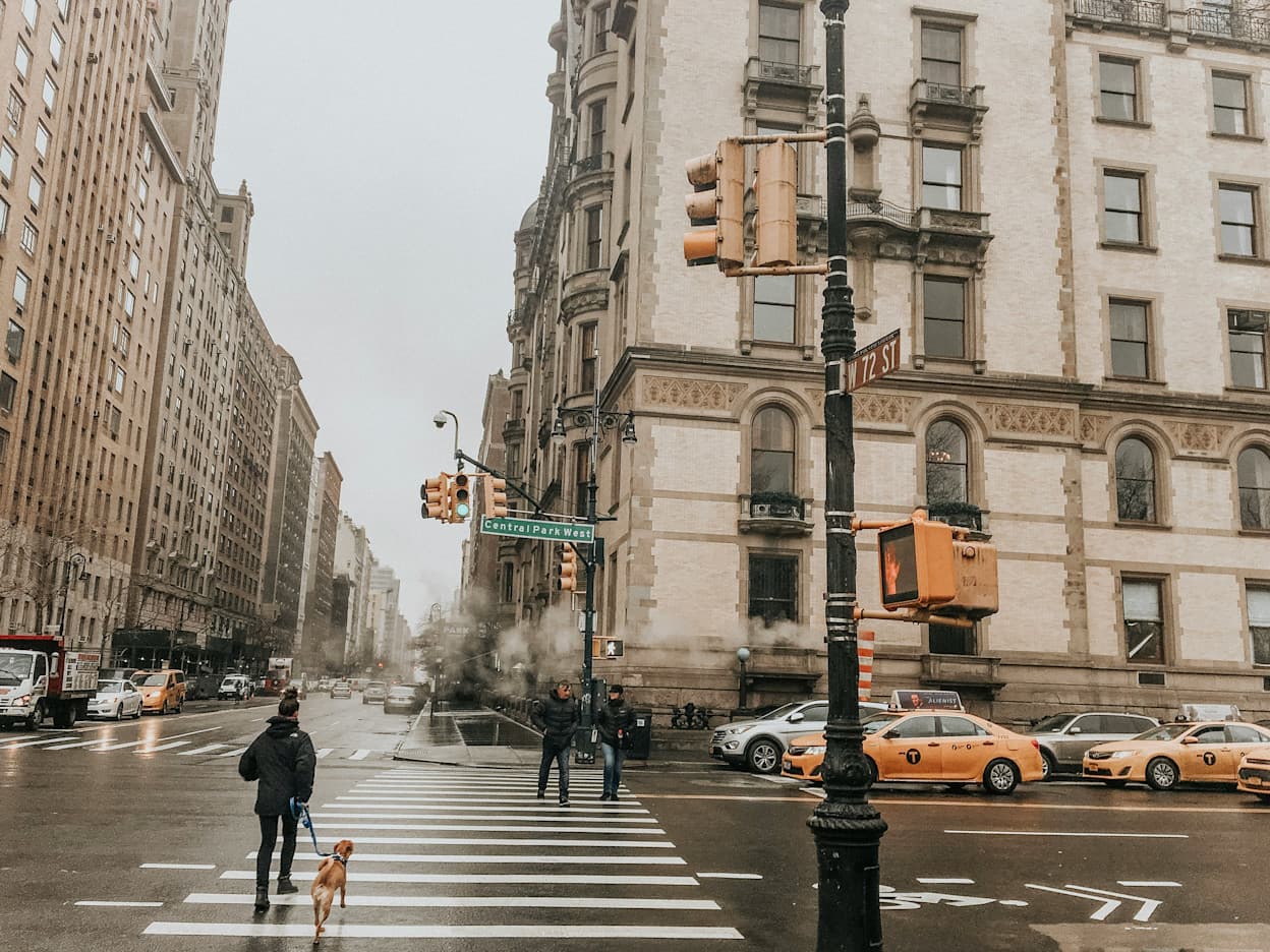 Skyscrapers and a crosswalk at Central Park West street of New York City in the Upper West Side neighborhood on a cold and rainy day.