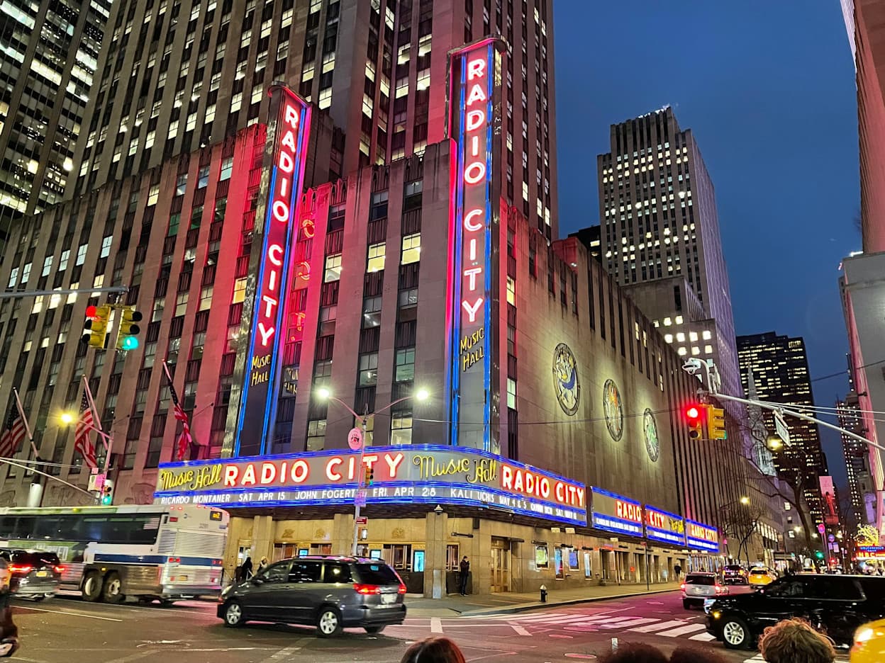 Skyscrapers and neon light signs at the Radio City Music Hall located in the Midtown Manhattan neighborhood of New York, City.