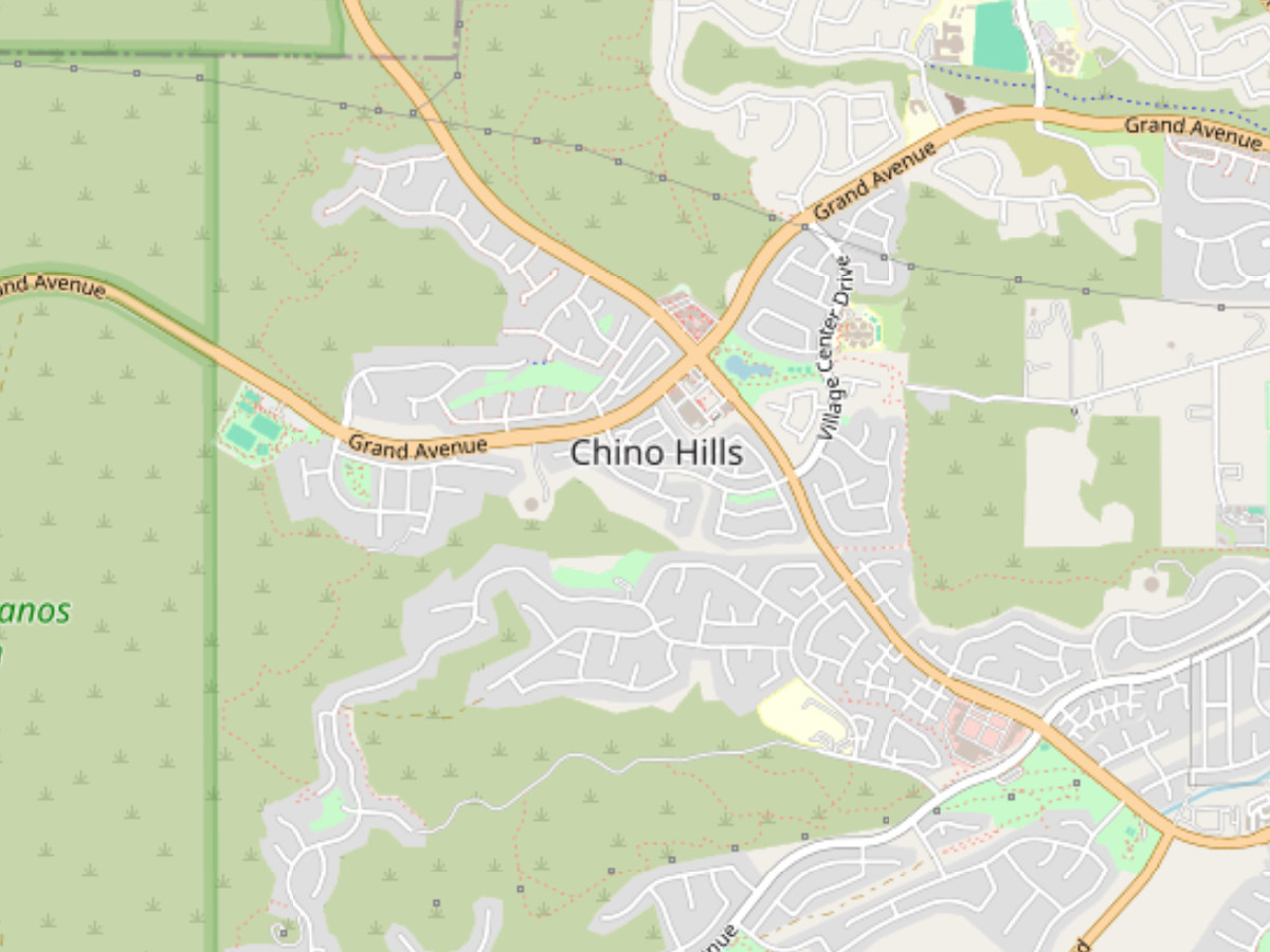 Map showing the Chino Hills area with streets including Grand Avenue and Village Center Drive, surrounded by green parkland and residential neighborhoods.