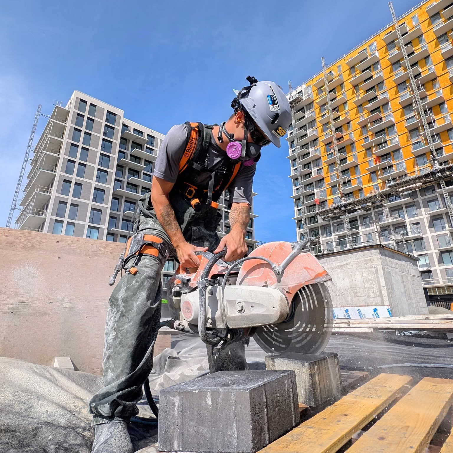 Worker cutting a concrete block on a job site with the Biolift Carbon exoskeleton