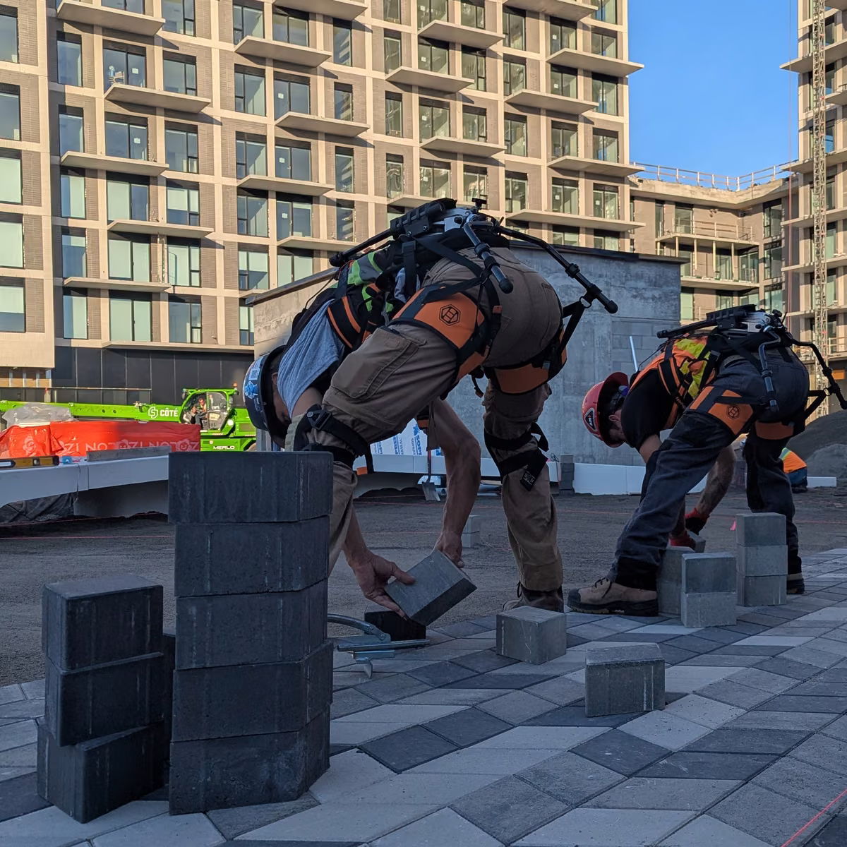 Équipe d'aménagement paysager qui pose des pavés avec des exosquelettes Biolift Carbon