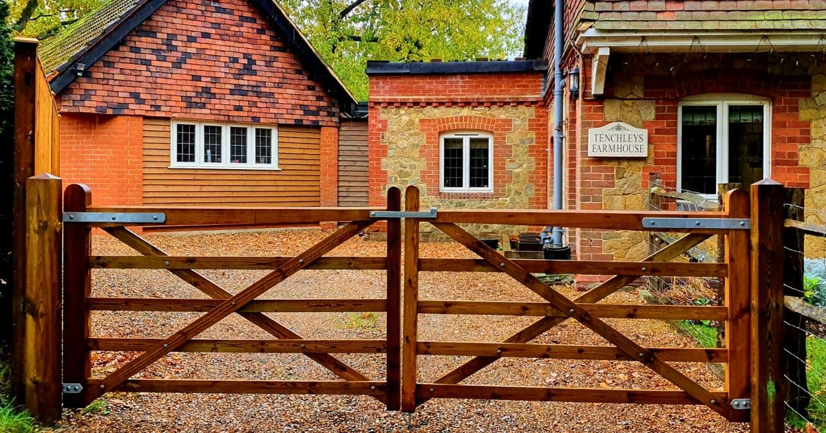 Closeboard timber fence with Green Leaves Fencing & Gates sign installed on a slope in East Grinstead.