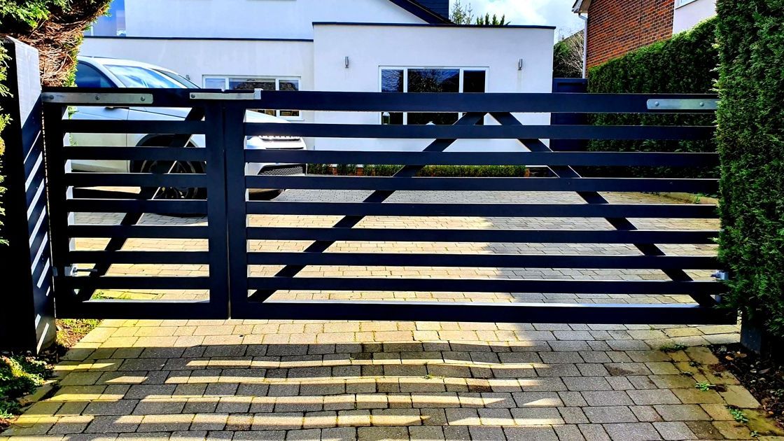 Closeboard timber fence with Green Leaves Fencing & Gates sign installed on a slope in East Grinstead.