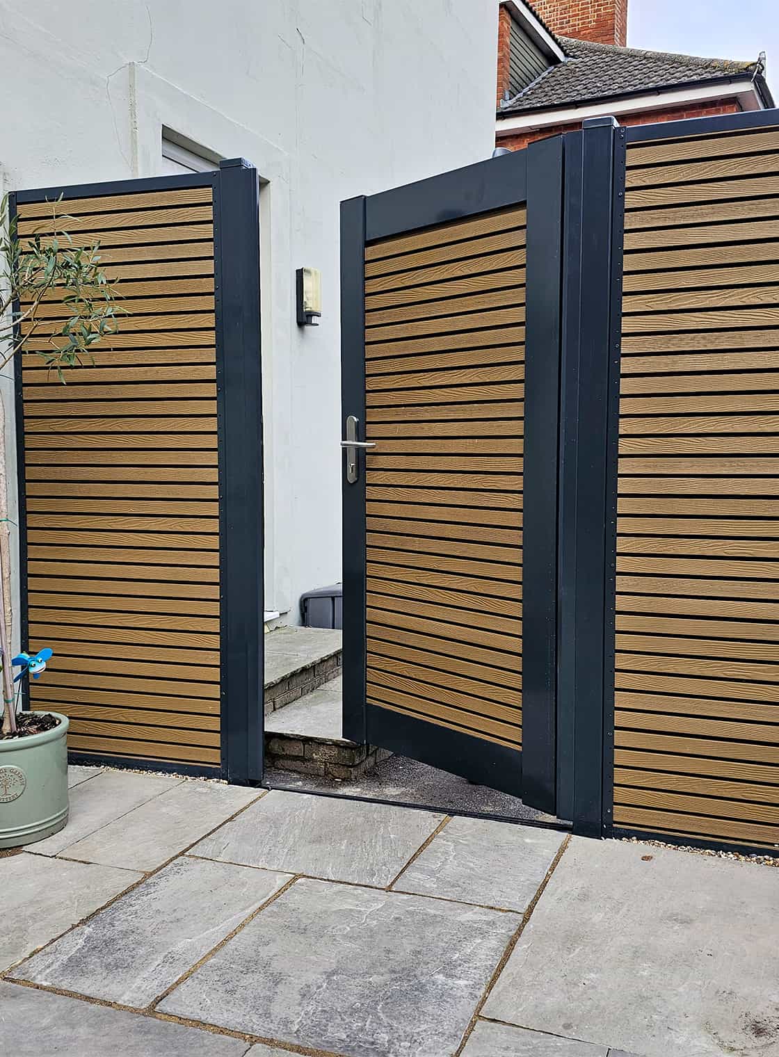 Timber fencing and gate installation in a landscaped garden setting, showing clean lines and natural finish.