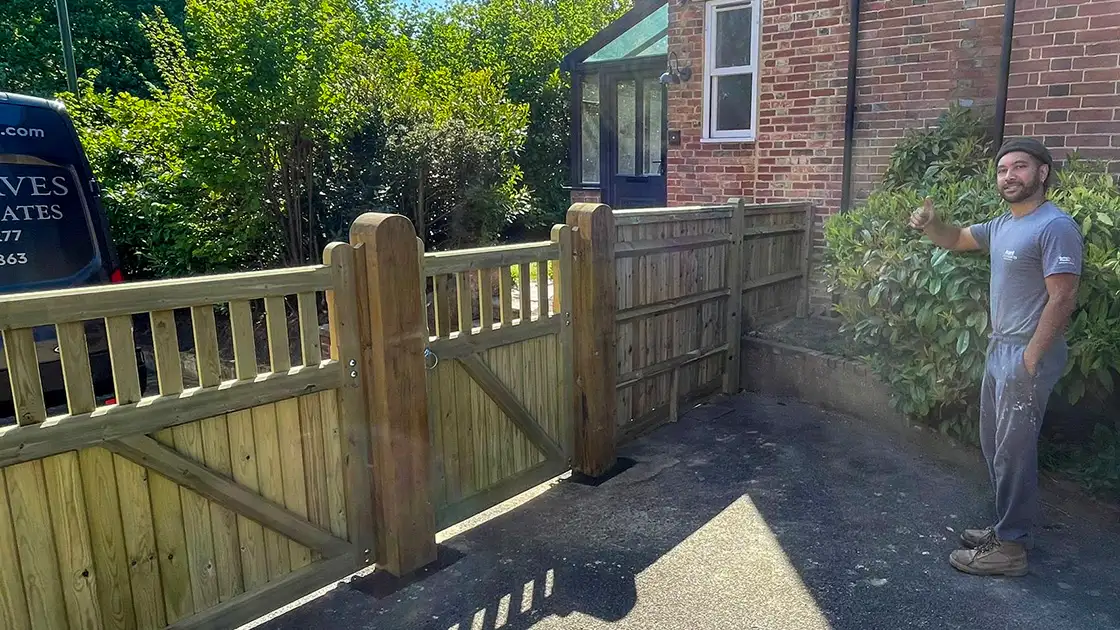 Closeboard timber fence with Green Leaves Fencing & Gates sign installed on a slope in East Grinstead.