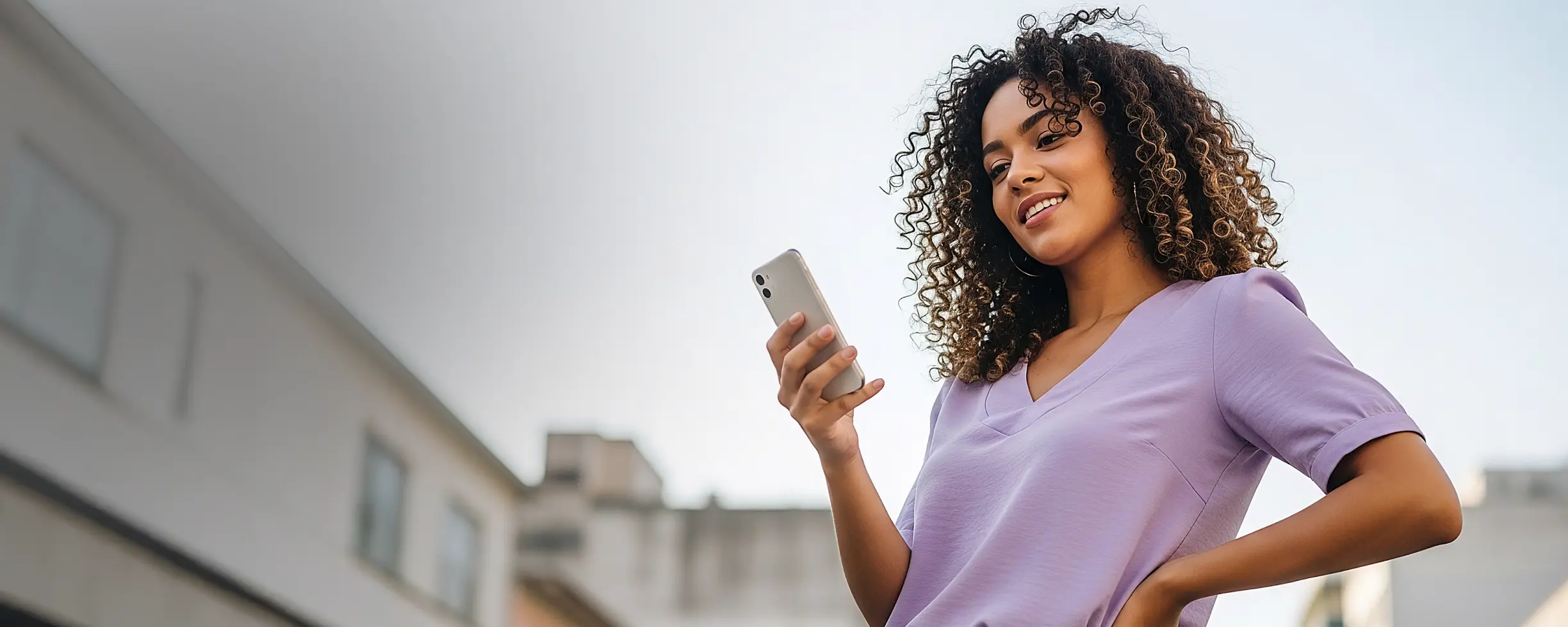 Imagem de mulher olhando para a tela do celular utilizando a verificação de identidade da Unico