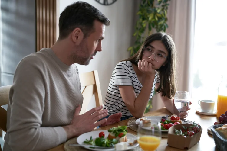 Father sitting at dinner table with his daughter