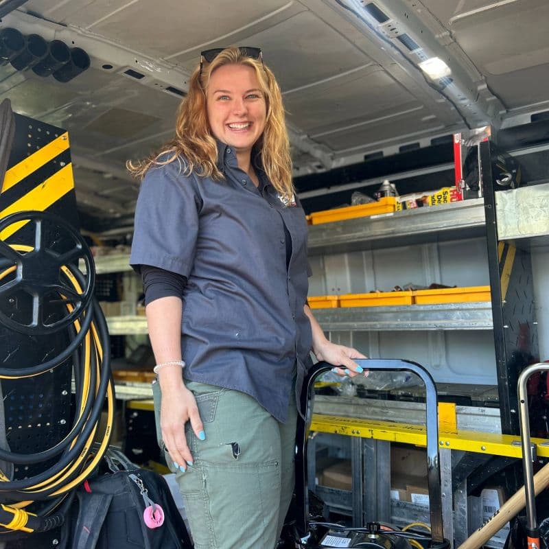 Smiling woman inside a well-equipped work van going to a project.