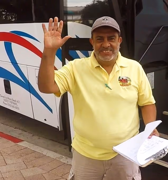 Amichevole autista di autobus che sorride e saluta i passeggeri sull'autobus della Miami Tour Company a Bayside