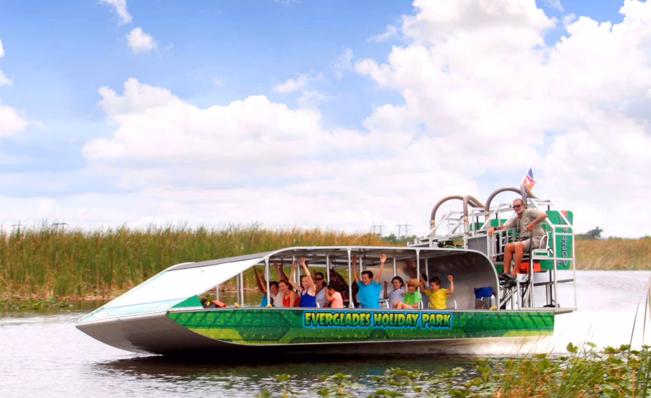 Green airboat speeding across the water in the Everglades