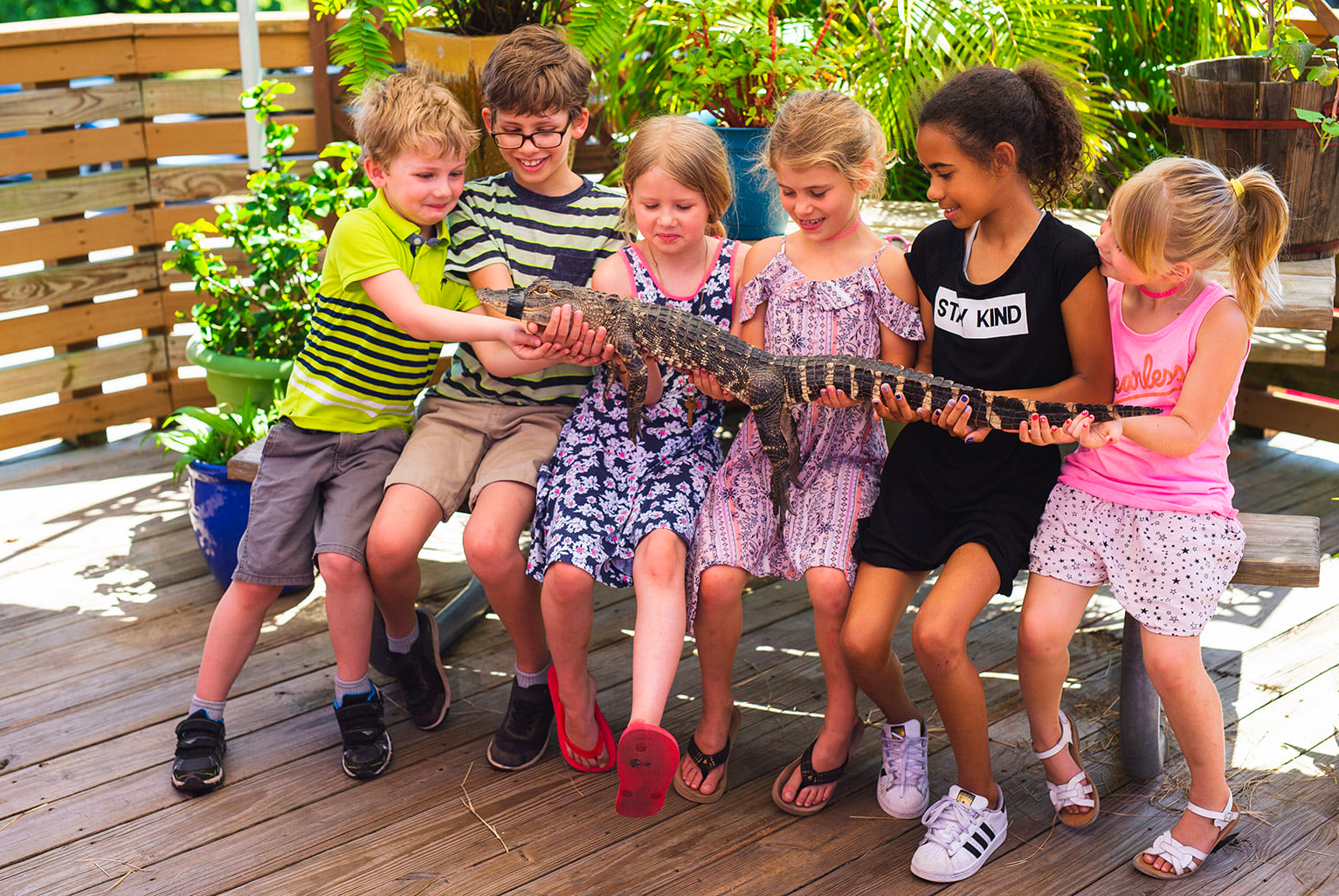 Six kids holding a giant snake