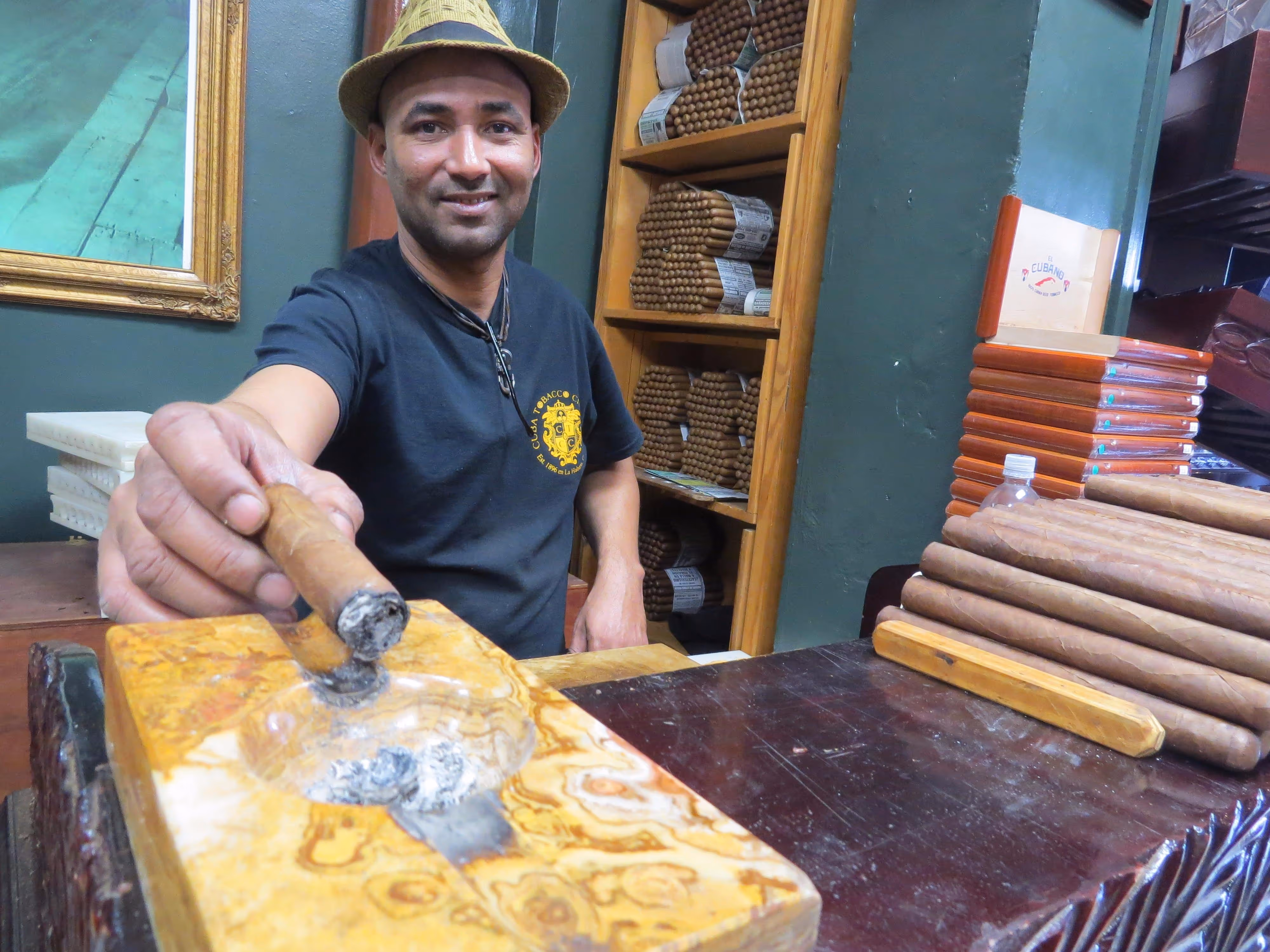 A smiling cigar-rolling master offering us a smoke