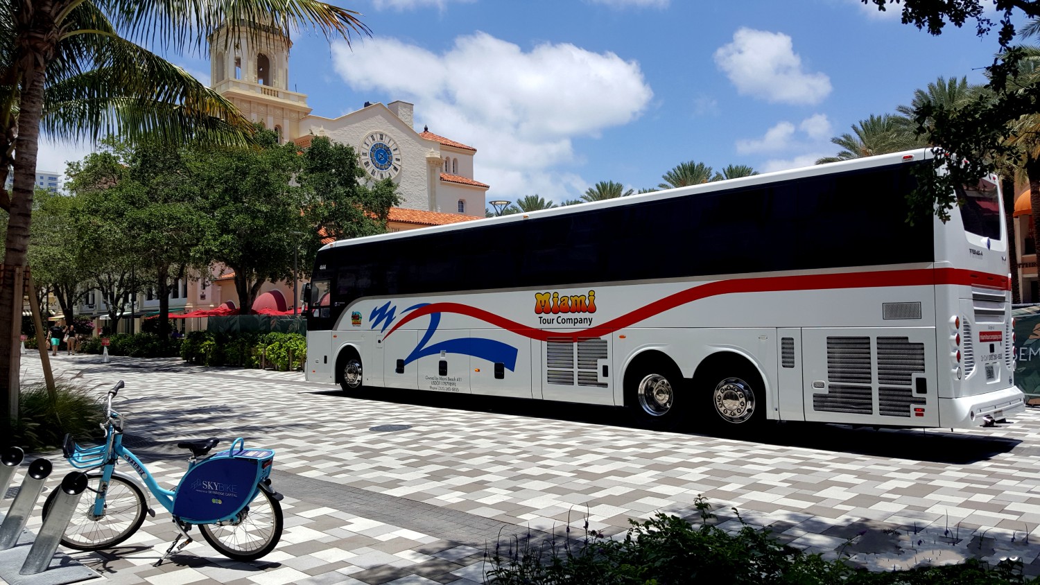 Private Everglades charter bus picking up passengers in Miami under blue skies
