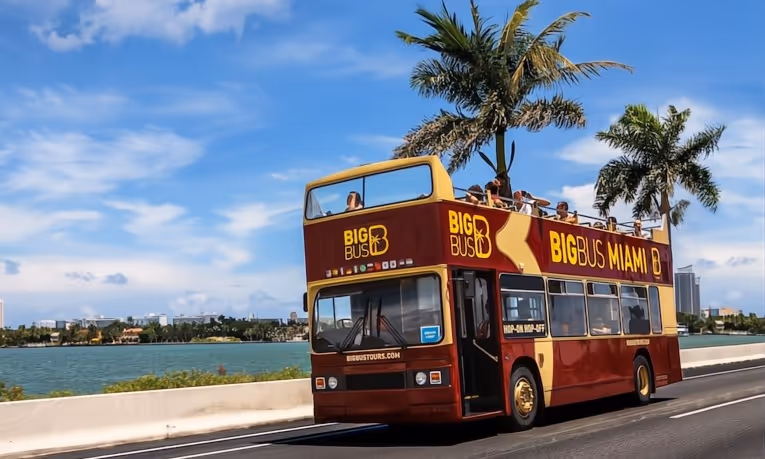 Double-decker bus driving across MacArthur Causeway toward Miami Beach