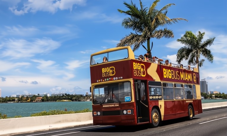 Double-decker bus driving across MacArthur Causeway toward Miami Beach