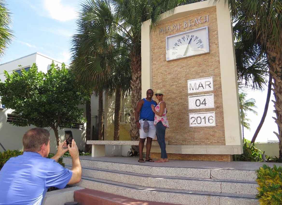 Young couple posing at the Art Deco clock monument on Ocean Drive