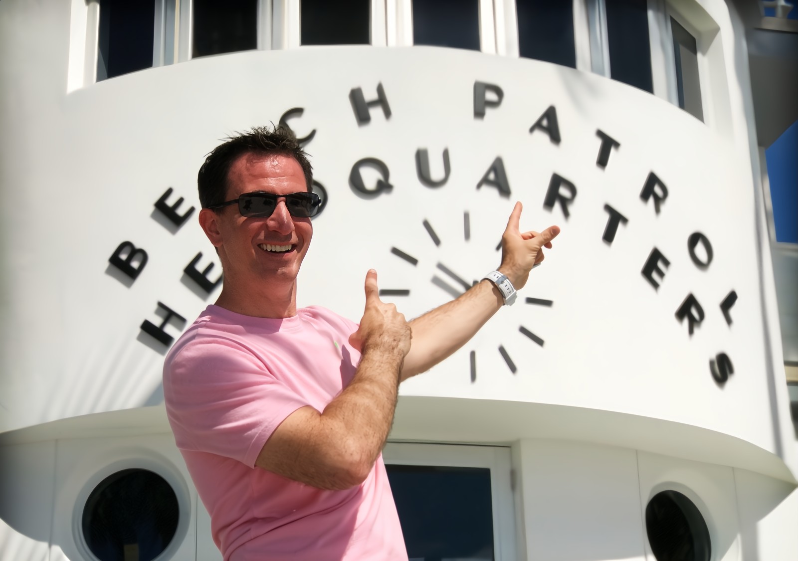 Smiling young man posing near the Beach Patrol Headquaters in Miami Beach