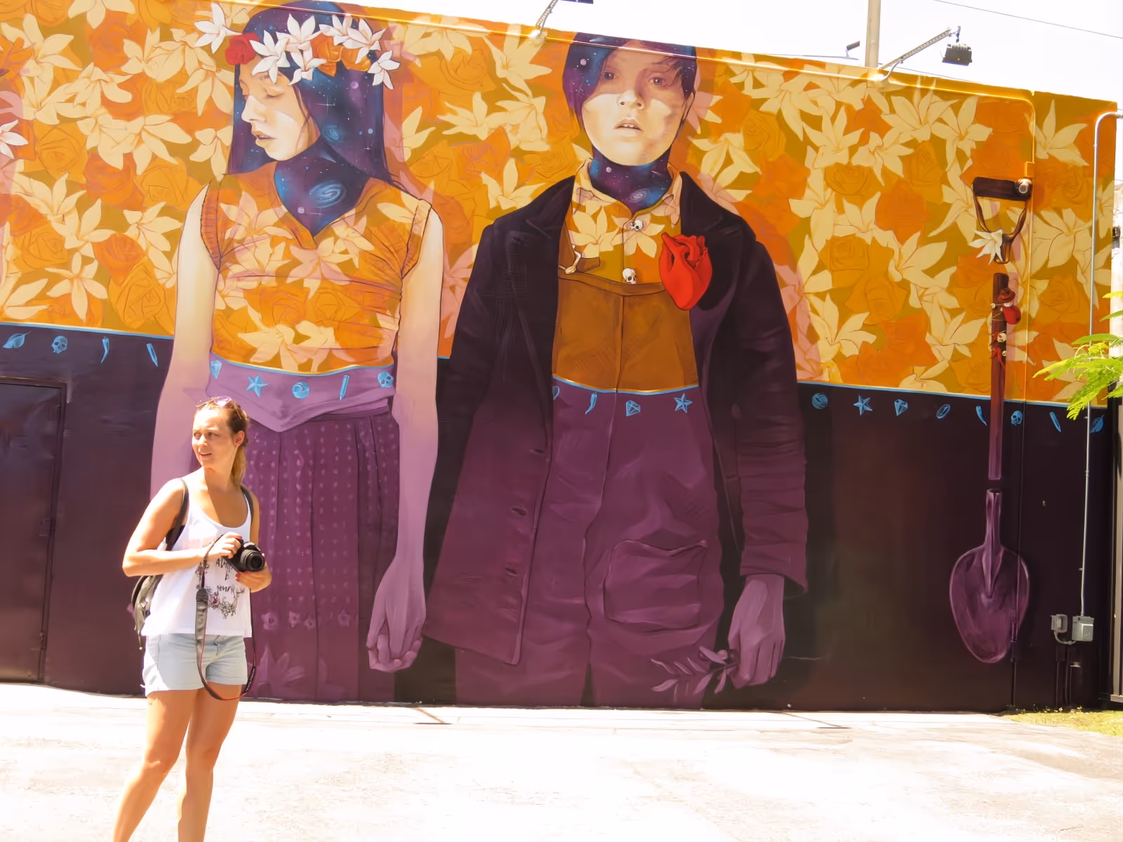 Young lady in shorts walks walking around looking for a perfect place to take a photo
