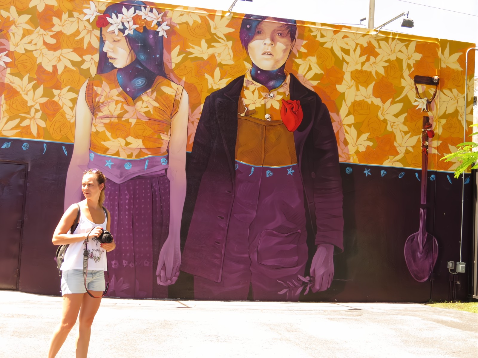 Young lady in shorts walks walking around looking for a perfect place to take a photo