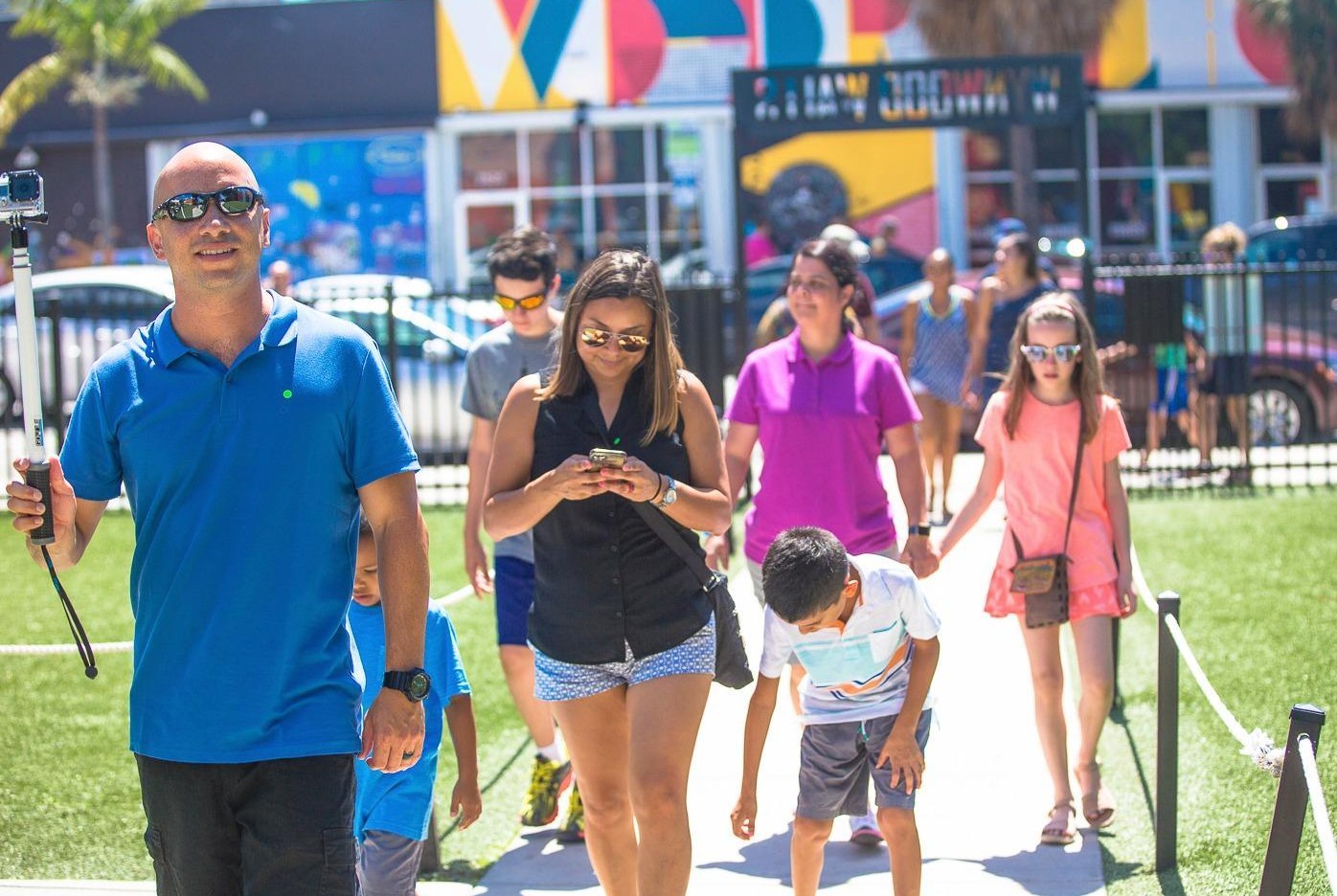Family of four holding a selfie stick walking into the Wynwood Walls