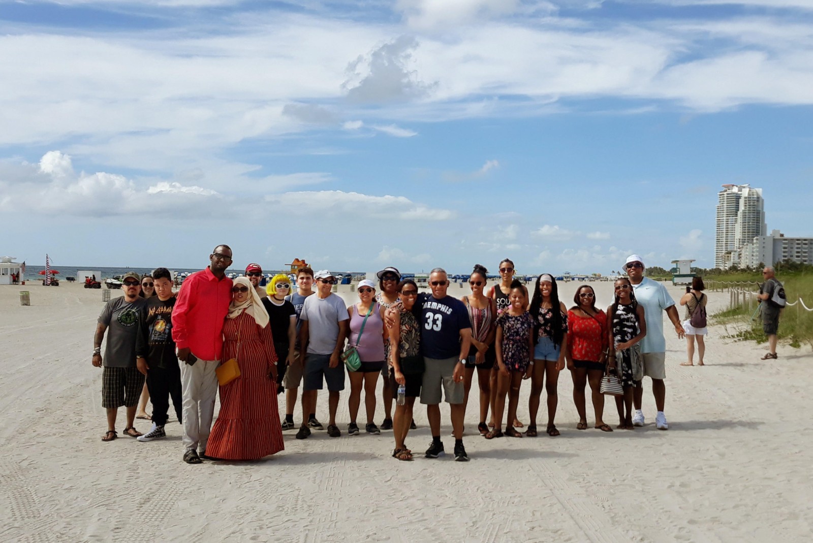 Diverse group of people posing on the beach under stunning blue skies in South Beach, Miami