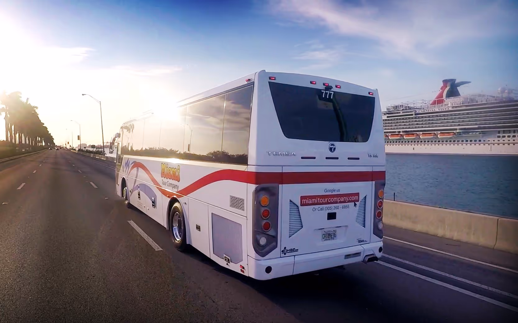 Bus charter driving past Carnival cruise ship