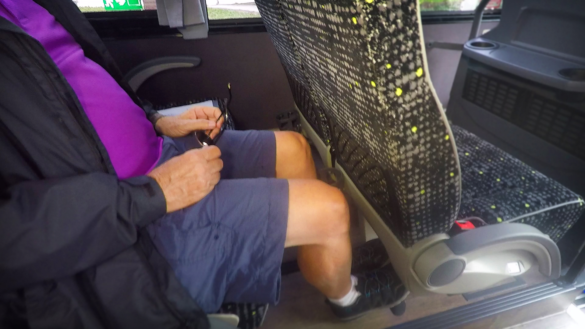 Tour bus driver showing amount of passenger leg room space