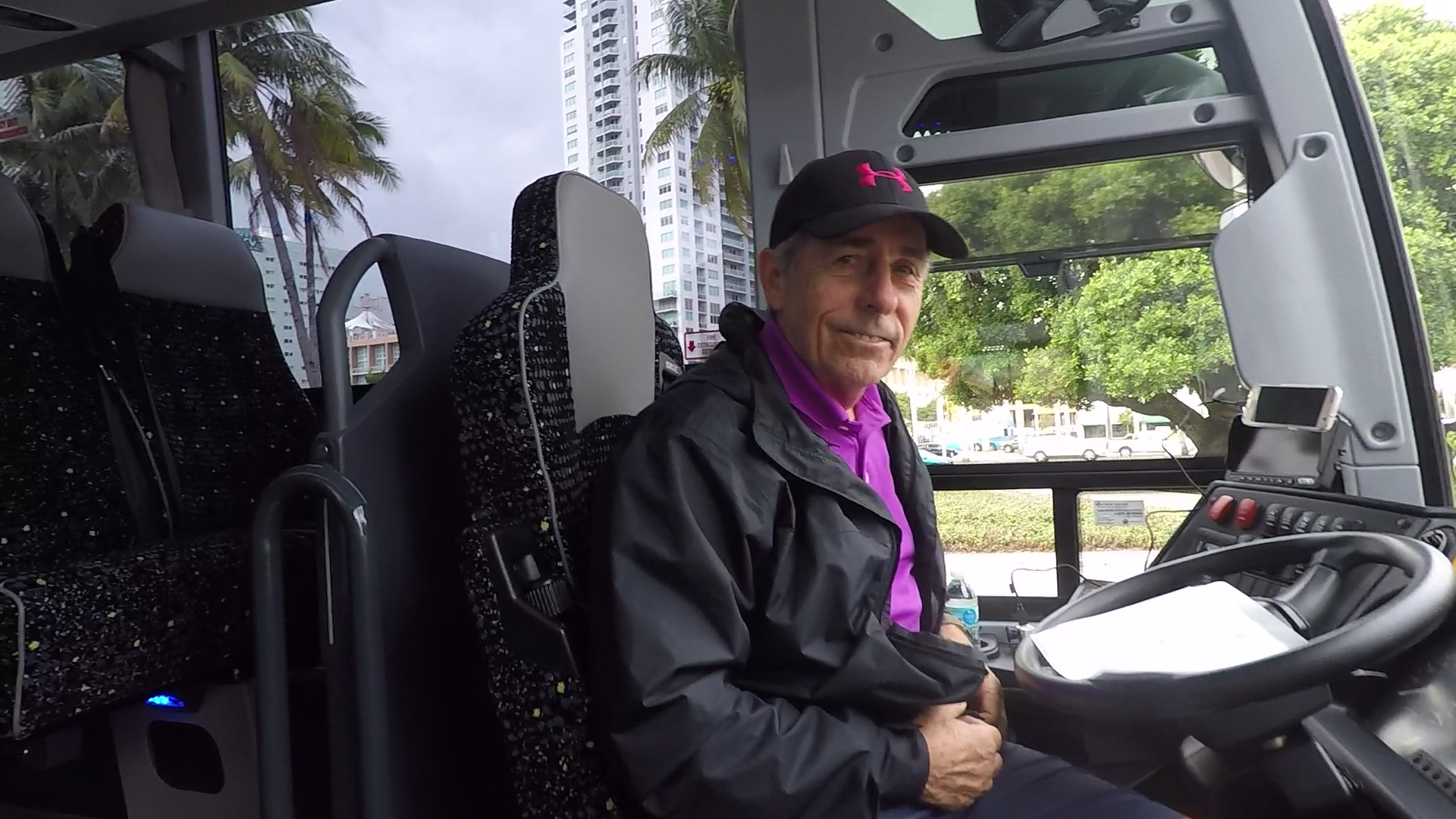 Smiling bus driver behind the wheel of the coach