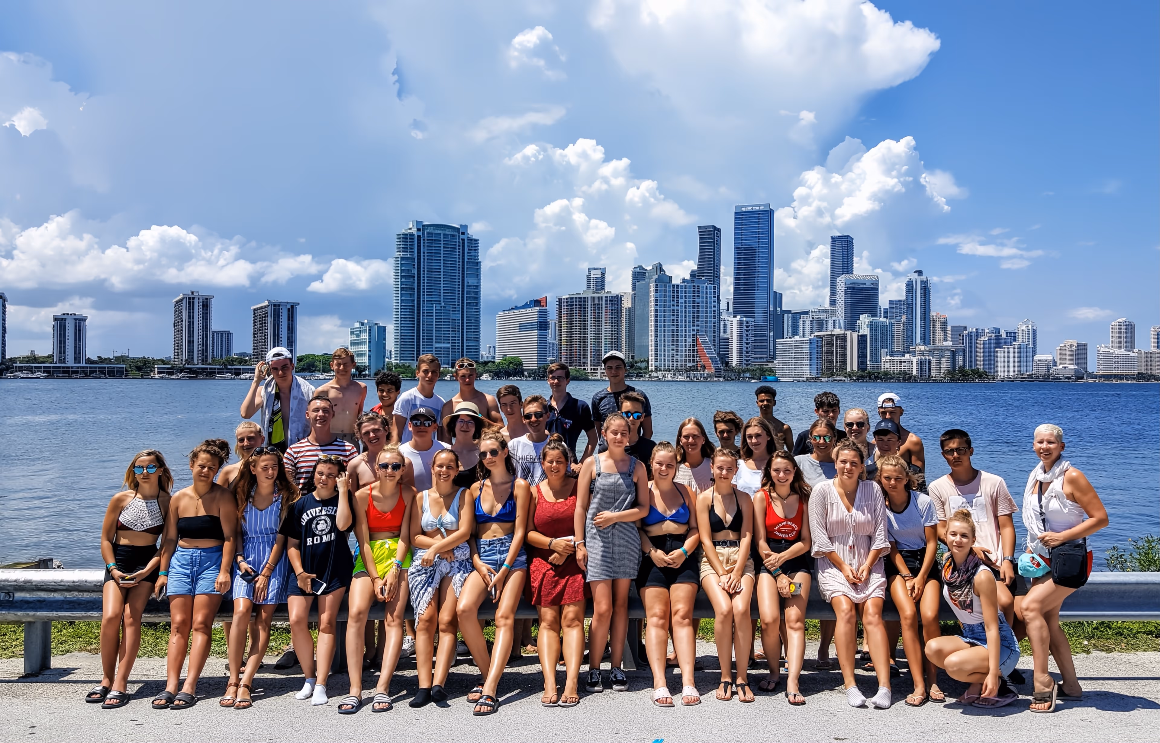 35 students taking a group phone with Miami skyline
