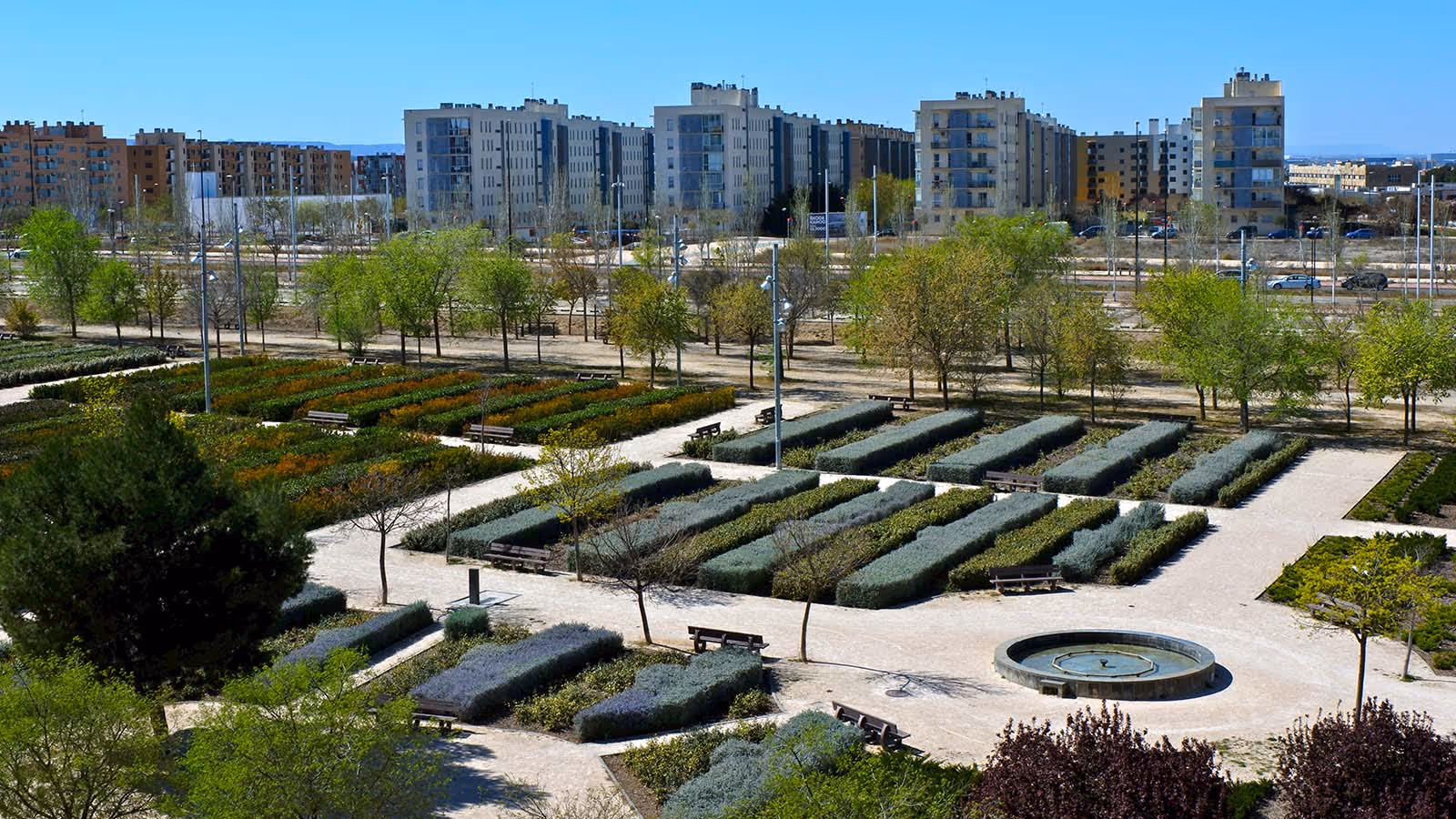 A large city park with a fountain and many trees.