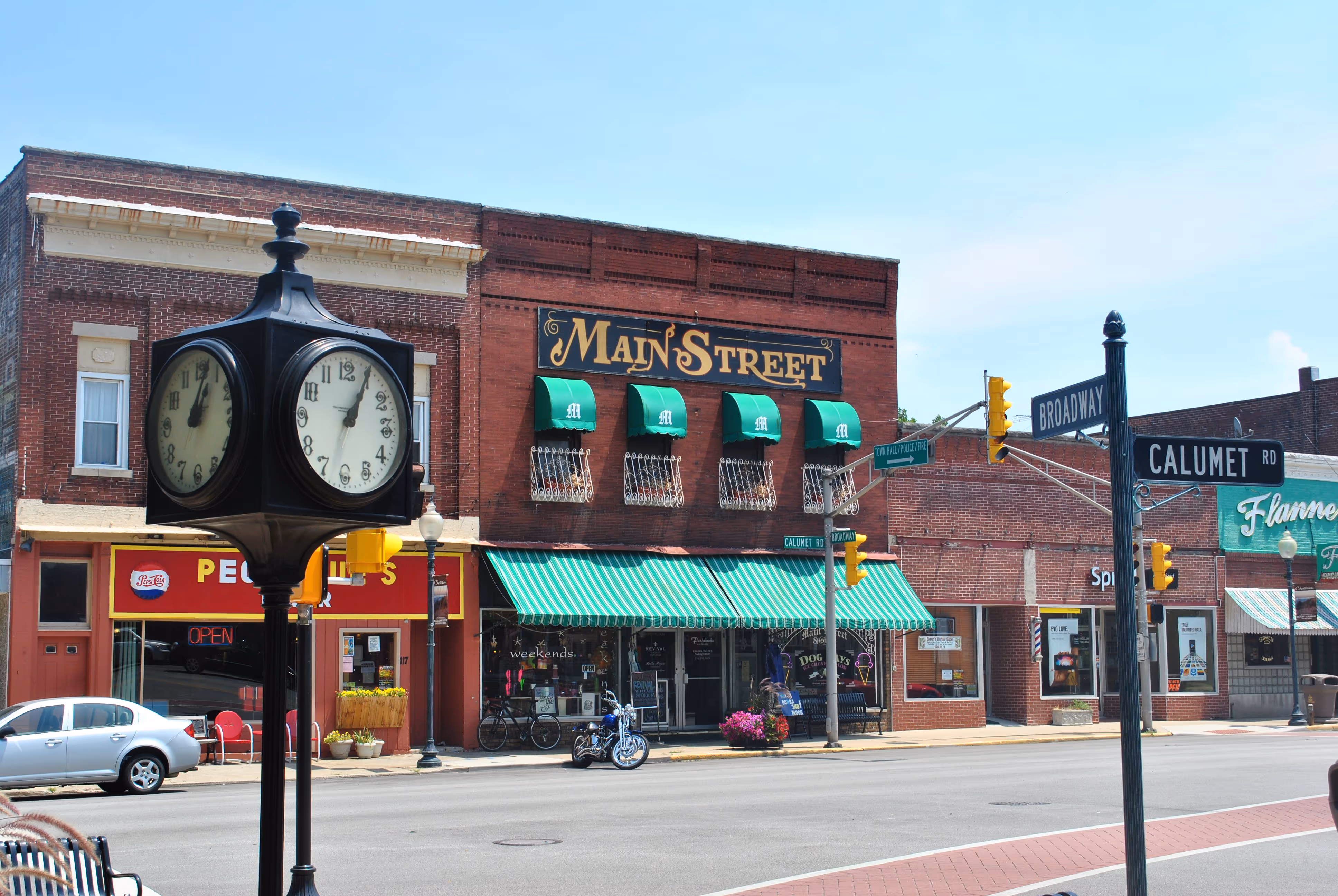 A clock on a pole in front of a store.