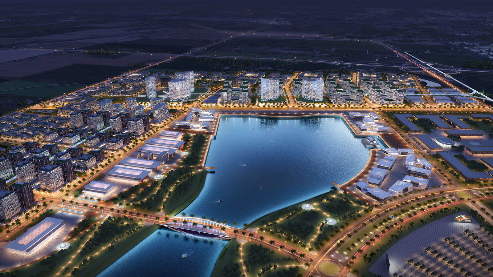 A cityscape at night with a large body of water and a bridge.