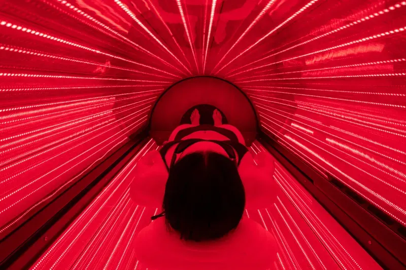 A member lying in the Breathe full-body red light bed