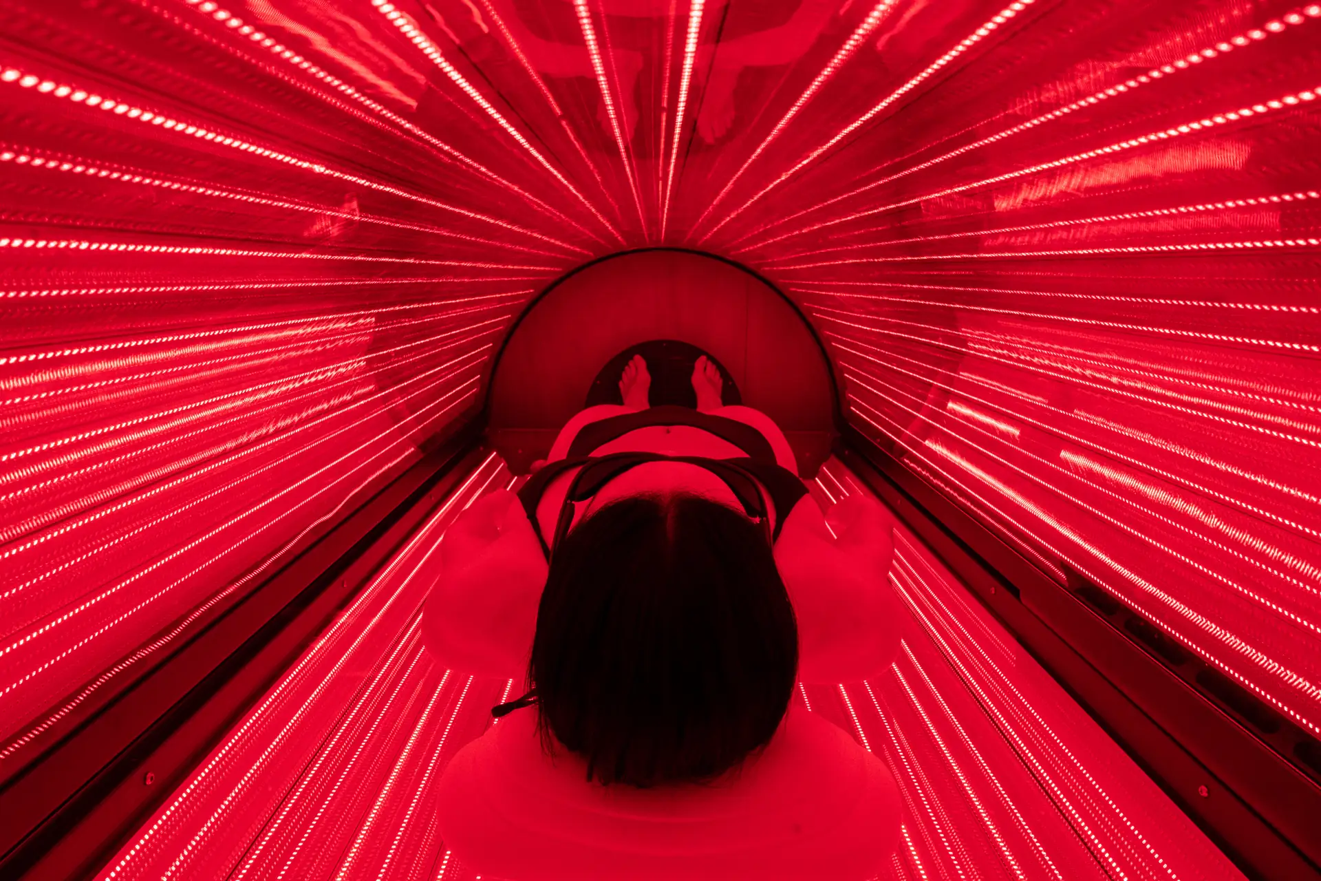 A member lying in the Breathe full-body red light bed