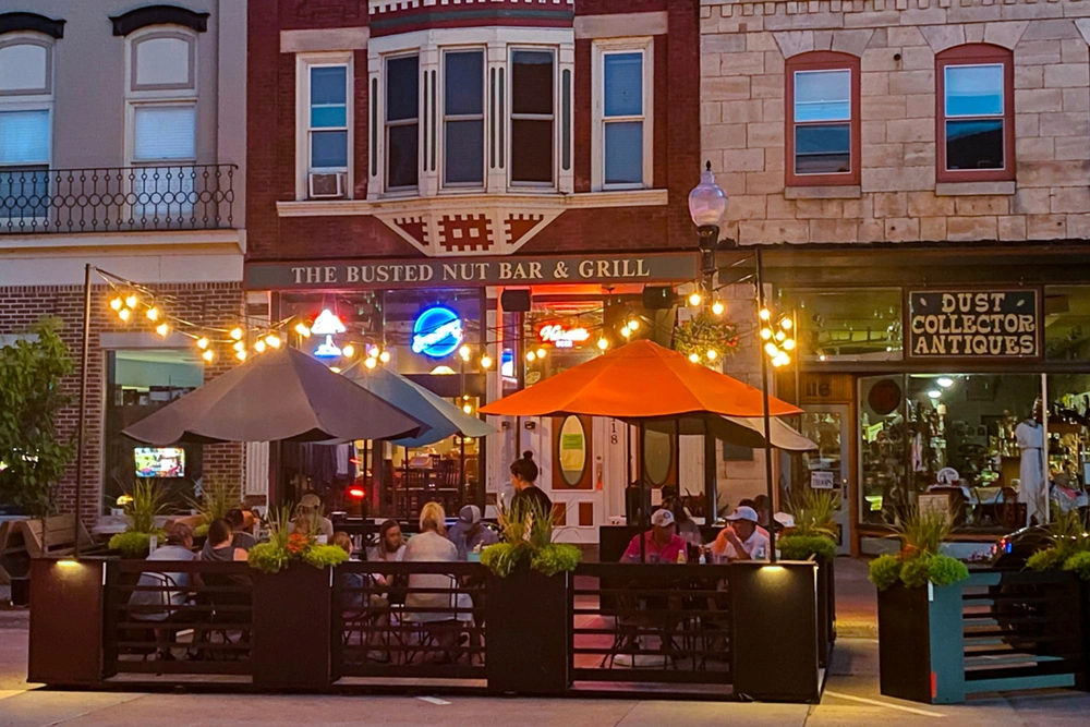 A picture of the Hastings parklet at dusk with cafe lights lit.
