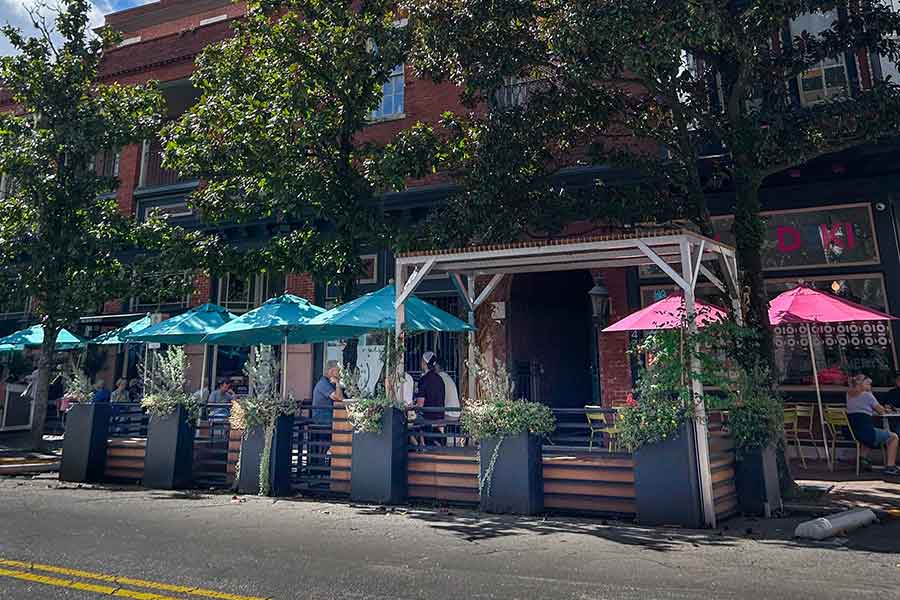 A row of vibrant red umbrellas lined up against a neutral background, creating a striking visual contrast.