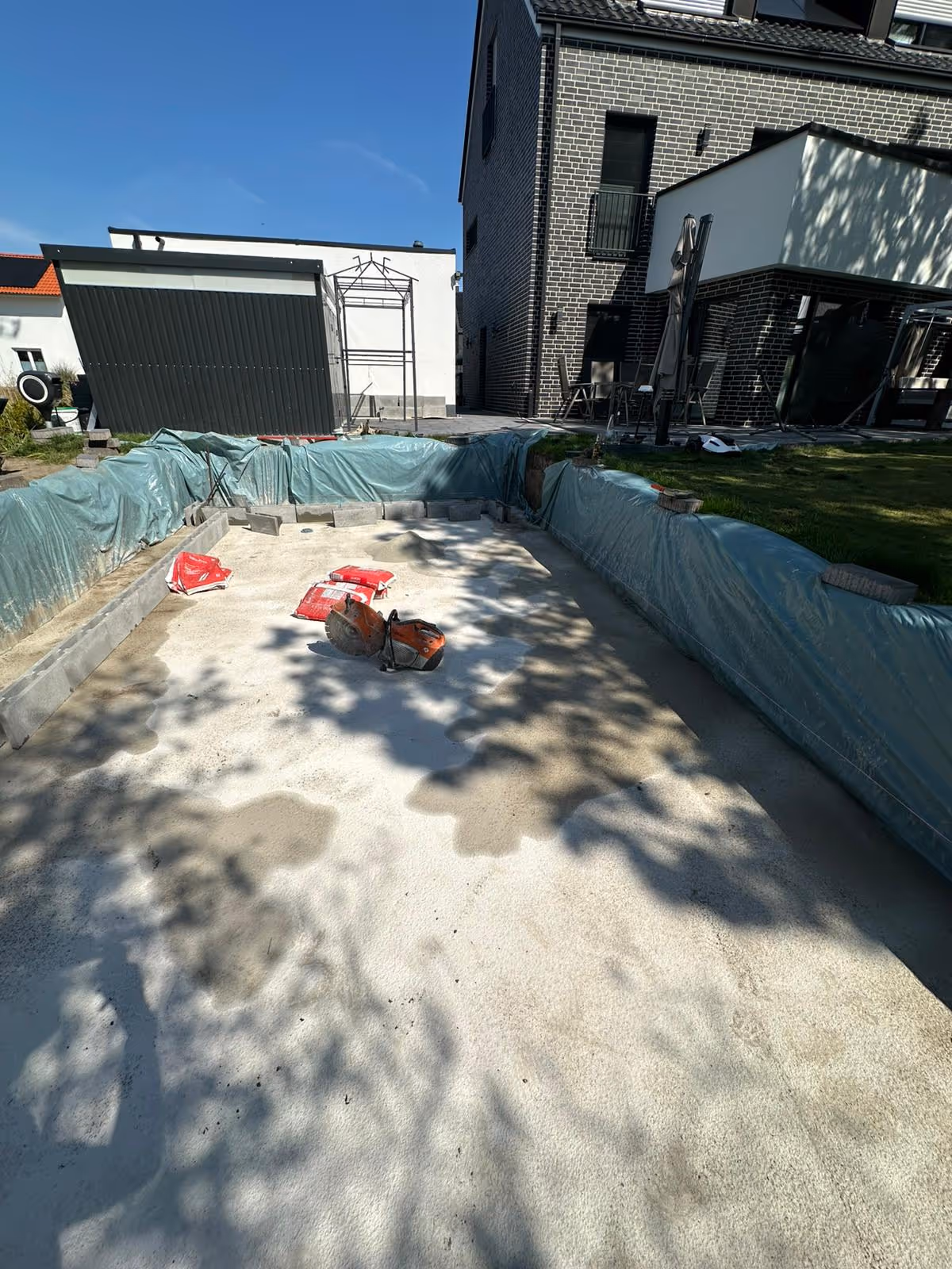Aushub der Baugrube für den Pool mit vorbereiteter Betonbodenplatte und Schutzplane - Lindemann Bau GmbH