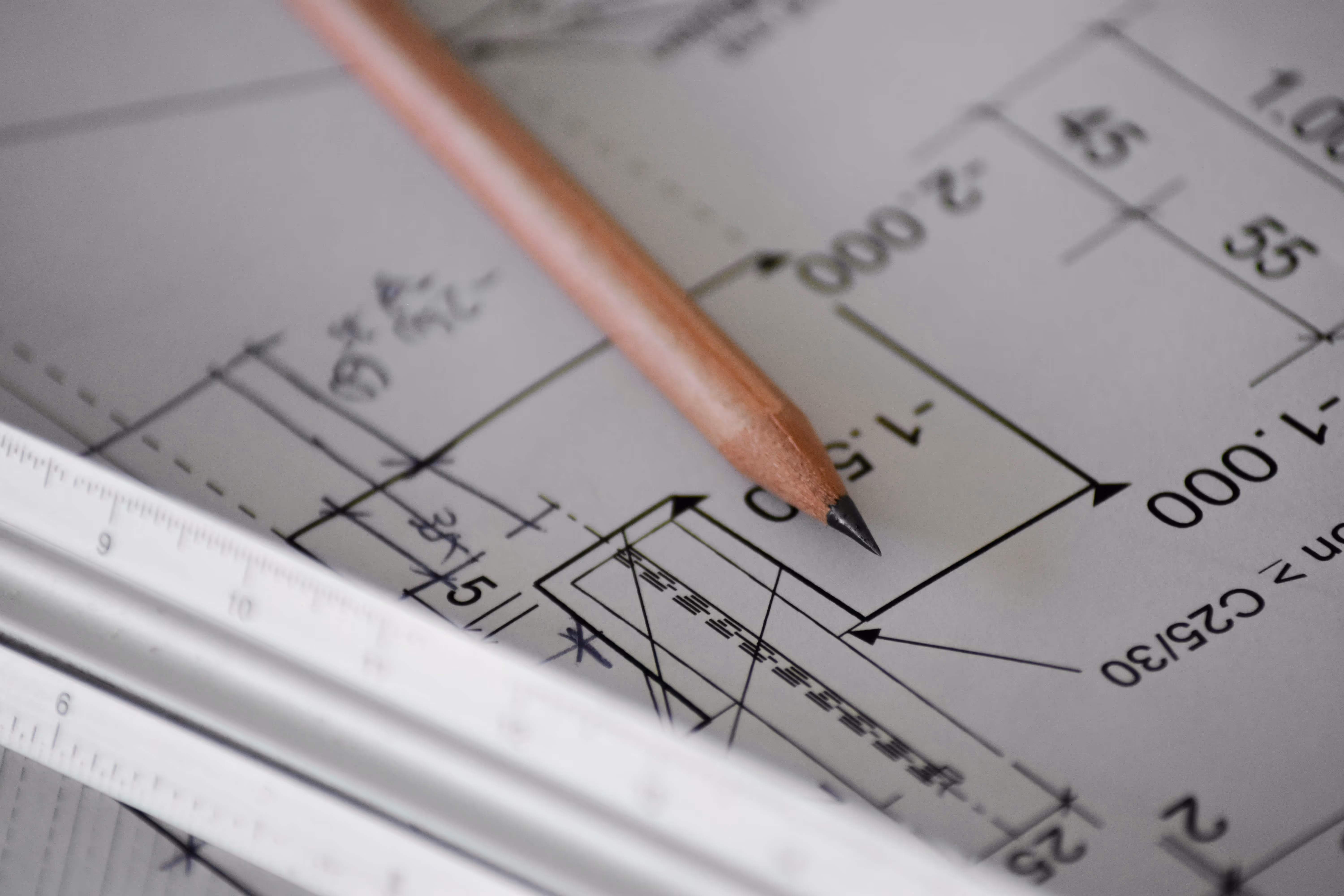 Detailaufnahme eines Bauplans oder einer Zeichnung mit Bleistift und Lineal – Planung und Architektur - Lindemann Bau GmbH